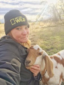 Woman posing with goat.